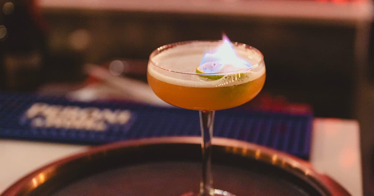 A flaming signature cocktail prepared for service